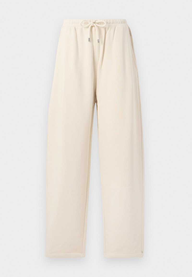 Cream-colored sweatpants made from soft fabric, featuring a drawstring waistband, loose fit, and side pockets.