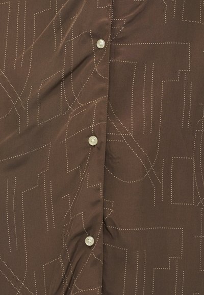 Καφέ ύφασμα με ανοιχτόχρωμα διακοσμητικά γεωμετρικά σχέδια σε γραμμές και τρία εμφανή πέρλα κουμπιά στο κέντρο.