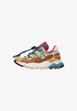 Mehrfarbiger Sneaker mit blauen und grünen Schnürsenkeln, braun-beigem Obermaterial, rotem Kragenfutter und dicker weißer Sohle mit blauen und schwarzen Profilakzenten.