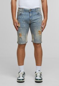 Traper šorts u svijetloplavoj boji, s istrošenim dijelovima i detaljima prskanja, klasičnog pet-džepnog dizajna i srebrnim hardverom.