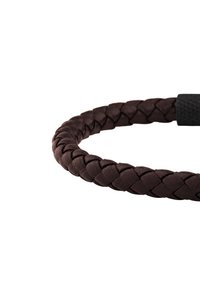 Pulsera de cuero trenzado marrón oscuro con cierre magnético negro sobre un fondo blanco.
