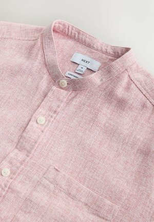 Camisa rosa claro con textura, cuello mandarín, dos botones y un solo bolsillo en el pecho. Etiqueta con la marca "NEXT", talla M.