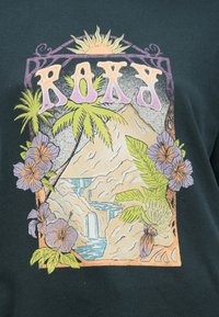 T-shirt en coton vert foncé présentant un motif coloré représentant un paysage tropical avec des palmiers, des fleurs, des montagnes et une cascade.