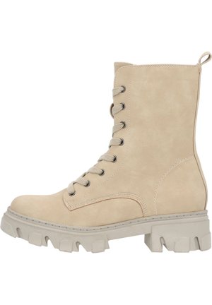 Bottine en suédine beige avec un laçage à l'avant, des œillets métalliques et une semelle en caoutchouc épaisse présentant un design à crampons.