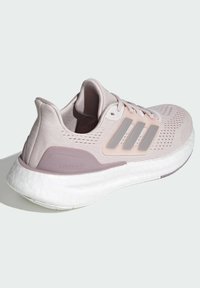 Light pink athletic shoe with mesh upper, three grey stripes, padded collar, and white boost sole. Features a textured design.