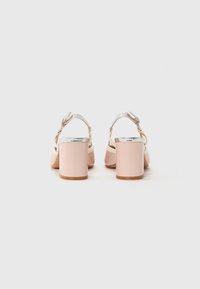 I sandali rosa con tacco a blocco presentano una elegante fibbia argentata e una superficie liscia. Il design posteriore include una cinghia per una vestibilità sicura.