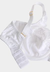 Hvid blondebh med justerbare stropper, teksturerede stoffer og guldfarvede detaljer. Har elastisk bånd og hægte- og øjnelukning.