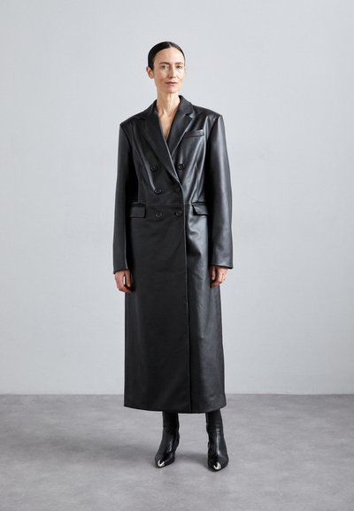Cappotto doppiopetto in pelle nera con una silhouette lunga, ampie rever e bottoni frontali. Texture liscia con una finitura lucida.