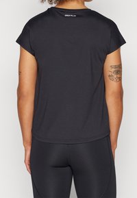 Camiseta deportiva negra con mangas tipo cap sleeve, cuello redondo y una tela texturizada. Marca "ONLY PLAY" en la parte superior de la espalda.