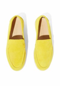 Mocassini in suede giallo con texture liscia, punta rotonda e cuciture decorative lungo i bordi. Design minimalista senza dettagli in metallo.