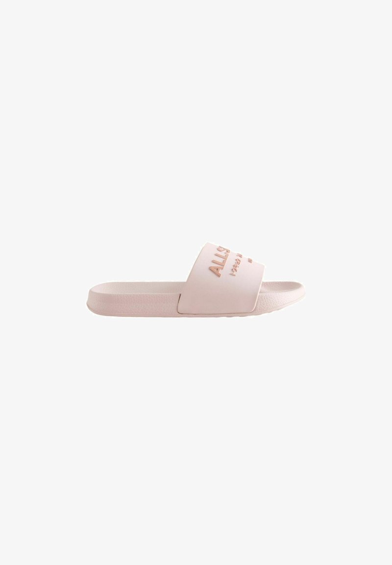 Sandale à glissière rose clair avec une semelle texturée et une large bride présentant un texte embossé dans une teinte légèrement plus foncée.