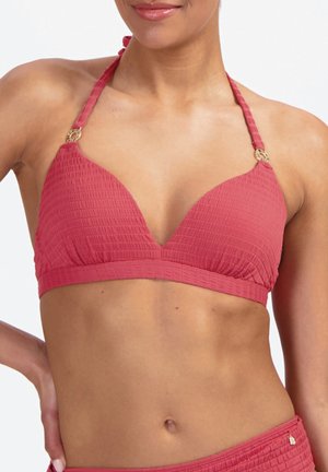 Donna che indossa un top bikini a collo halter rosa testurizzato con dettagli ad anello dorato e slip coordinati, che mostra l'addome e parte del torso.