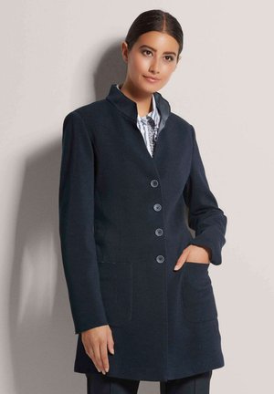 Navy wool blend coat with a collar, six buttons, and two front pockets; features a tailored fit and smooth texture.
