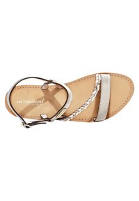 Sandal en cuir argenté avec design de lanière tressée. Présente une semelle plate et une lanière ajustable au niveau de la cheville. Détails cousus le long des bords.