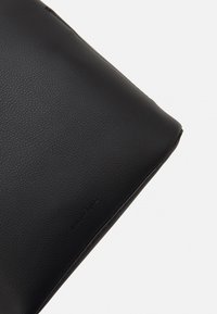 Sort læder tablet etui, rektangulær form, tekstureret overflade, subtil prægning af brandet, lynlåslukning øverst, glatte kanter.