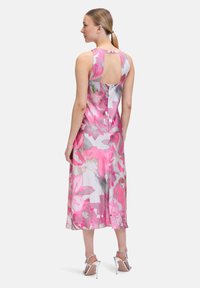 Blumendruck-Midi-Kleid mit einem pink-weißen Design, ärmellosem Schnitt und einem Schlüssellochdetail im Rücken, aus leichtem Stoff gefertigt.