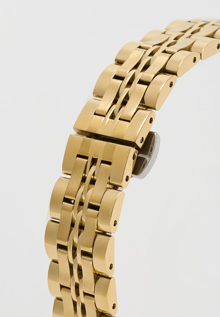 Gouden metalen horlogeband met vergrendelende schakels, voorzien van een gepolijste afwerking en een gladde textuur. Zichtbaar hardware omvat een sluitmechanisme.