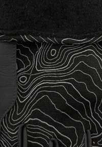 Gants texturés noirs arborant un motif topographique blanc, avec une paume en cuir et une partie supérieure en tissu, mettant en avant des détails précis et un contraste.
