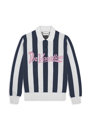 Young man with curly blond hair wearing a long-sleeve navy and white striped shirt with "On Vacation" in pink text.