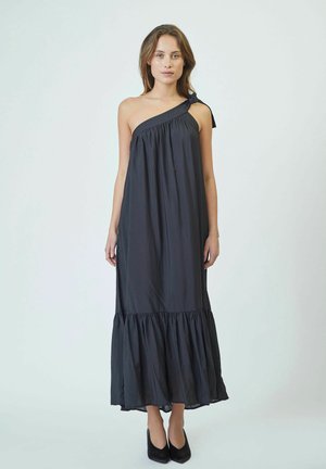 Abito maxi nero con spalla unica, in tessuto arricciato e orlo a volant. Realizzato in materiale leggero, con un laccetto sulla spalla.