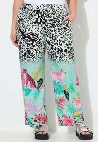 Lichte, gemusterde broek met wijde pijpen heeft een gradiënt van zwart-witte dierenprint naar kleurrijke tropische bladeren, met tijgers en heldere bloemen.