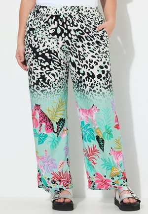 Leichte, gemusterte Palazzo-Hosen weisen einen Farbverlauf von schwarz-weißer Tierdruck zu buntem tropischen Laub auf, mit Tigern und leuchtenden Blumen.