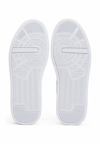 Suole in gomma bianca per sneaker con grip a motivo, presentante design a spina di pesce e circolari. "Tommy Hilfiger" impresso su una suola.
