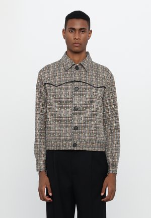 Brown checkered jacket with black accents and button closure. Features a collared neck and cropped design, made from textured fabric.