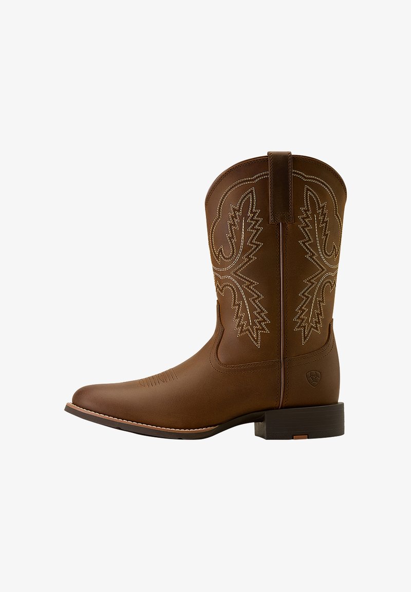 Brun cowboystøvle i læder med broderede detaljer, spids tå, syede accenter og en stablet hæl, der fremhæver en glat tekstur.