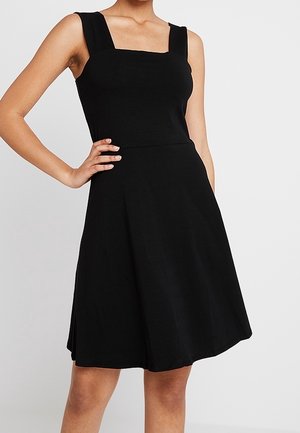Sort ærmeløs kjole med firkantet halsudskæring, tætsiddende overdel og udvidet skørt. Glat stof med mat tekstur uden synlige mønstre.