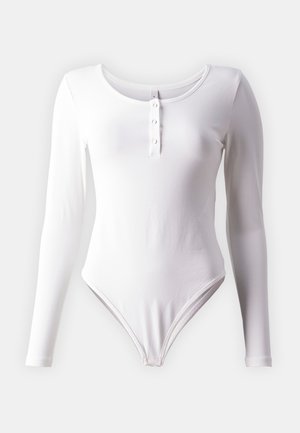 Body à manches longues blanc, ajusté, en tissu doux, avec un encolure ronde et une patte de boutonnage à cinq boutons à l'avant.