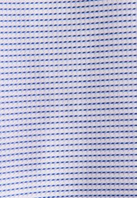 Geweven stof in lichtblauw en wit, met een geometrisch patroon van kleine vierkanten dat diepte en een ademende uitstraling creëert.