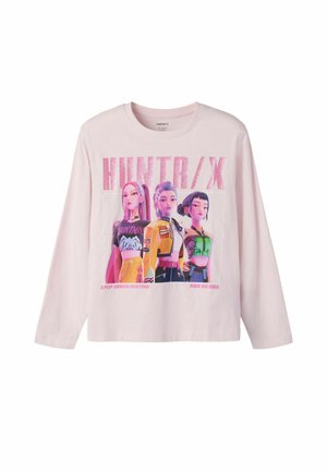 Chemise rose clair à manches longues avec graphisme animé de trois personnages féminins et texte "HUNTR/X" et "KPOP DEMON HUNTERS" sur le devant.