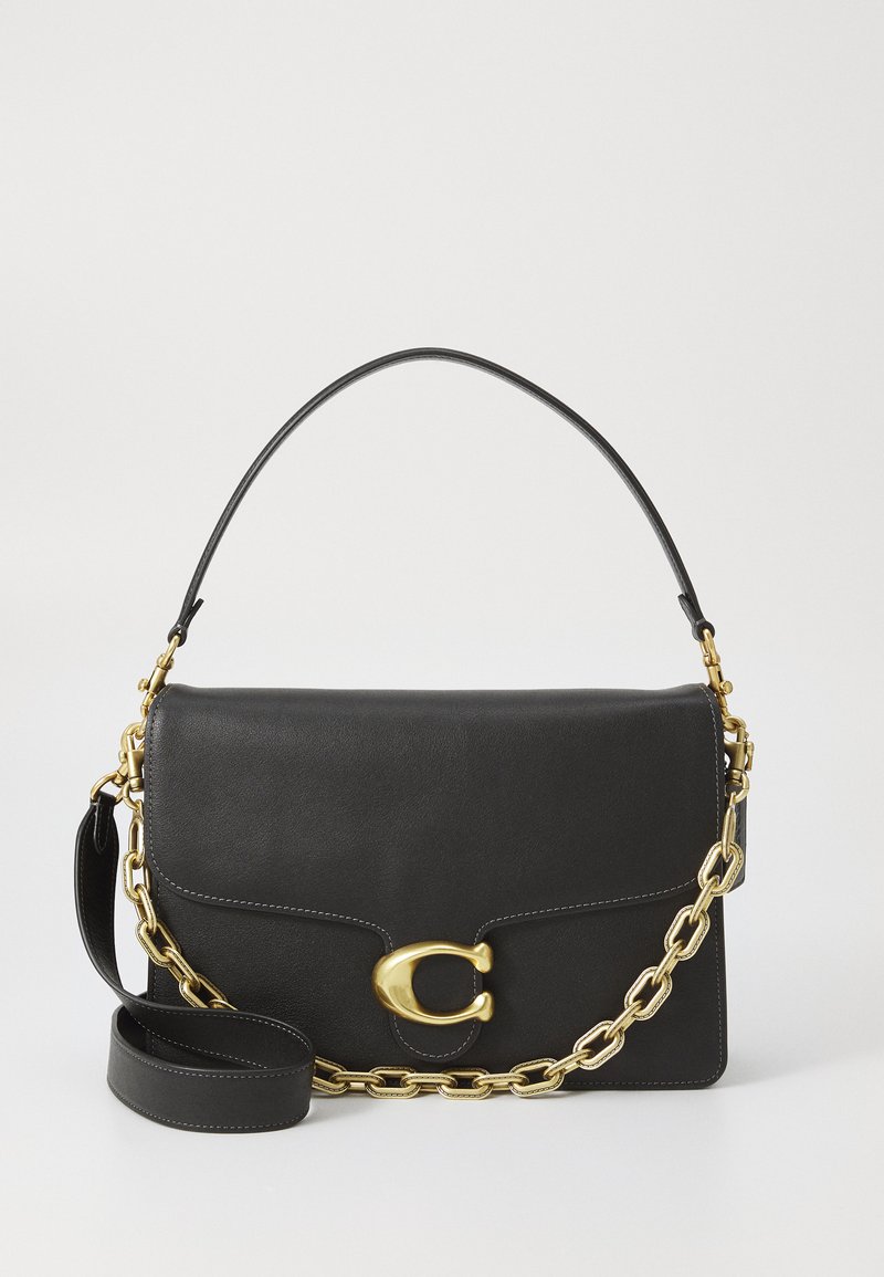 Sac à main en cuir noir avec une chaîne et un fermoir dorés, présentant une forme structurée, une texture lisse et une bandoulière réglable.