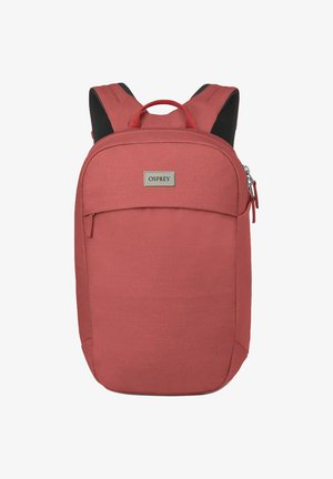 Sac à dos en tissu rouge avec une forme arrondie, une poche zippée à l'avant et des bretelles rembourrées. Présente une plaque de logo Osprey à l'avant.