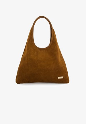 Brown suede tote bag with a slouchy hobo shape, a single shoulder strap, and a small metal logo accent on the side.