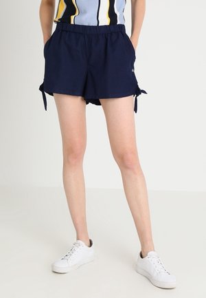 Pantaloni corti blu navy con vita elastica, dettagli a laccio sui lati e tasche laterali. Realizzati in tessuto leggero.