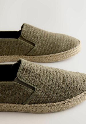 Rohelised kootud sisenõelaga kingad tekstuurse kangaga, elastsete külgedega ja naturaalsest nöörist tallaga. Lihtne disain, sobib igapäevaseks kandmiseks.