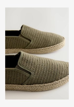 Groene geweven instapschoenen met textuurstof, elastische zijkanten en een natuurlijke touwzool. Eenvoudig ontwerp, geschikt voor vrijetijdsgebruik.