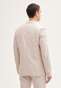 Helles beiges Leinen-Blazer mit Reverskragen, einreihigem Design und geknöpften Manschetten. Glatte Textur, taillierte Passform, minimale Details.
