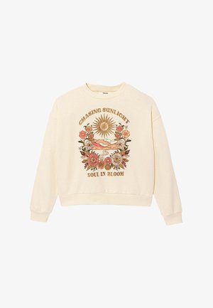 Sweat-shirt crème à manches longues avec graphisme floral et soleil, montagnes, et texte « Chasing Sunlight » et « Soul in Bloom » sur le devant.