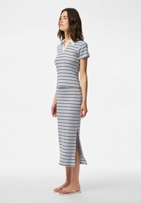 Robe rayée avec manches courtes, col polo et fentes latérales. Tissu doux et léger dans une palette de couleurs bleu, blanc et taupe.