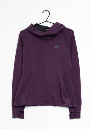 Fioletowa kangurka Nike z kapturem i otworami na kciuki na rękawach, wisząca na czarnym wieszaku na białym tle.