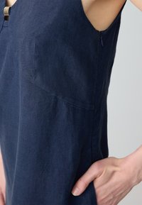 Navyblaues Leinenkleid mit ärmellosem Design, subtiler Textur, seitlichem Reißverschluss und rundem Ausschnitt. Bietet eine lockere Passform.