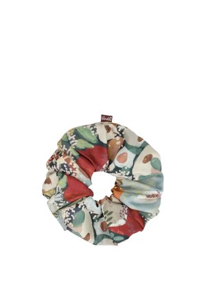 Scrunchie in tessuto con un motivo floreale morbido e multicolore in tonalità di verde, rosso, beige e blu, con una piccola etichetta marrone del marchio.