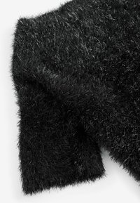 Czarny puszysty sweter o fakturowej powierzchni, z długimi, miękkimi włóknami przetykanymi metalicznymi nitkami, co daje efekt migotania.