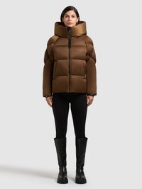 Giacca imbottita marrone con colletto alto imbottito, design trapuntato orizzontale, chiusura frontale con cerniera e tasche laterali, abbinata a leggings neri e stivali.