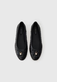 Μαύρες δερμάτινες μπαλαρίνες με υφασμάτινο σχέδιο, στρογγυλή μύτη και διακοσμητική χρυσή μεταλλική λεπτομέρεια μπροστά.