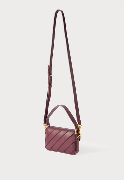 Mörkröd läderhandväska med diagonala sömmar, justerbart band och guldhardwaredetaljer. Kompakt form med handtag upptill och möjlighet att bära som axelväska.