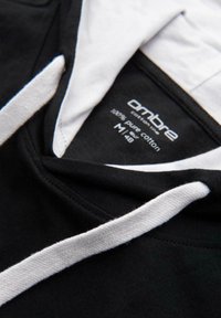 Černá mikina s bílými šnůrkami a vnitřním podšívkou, na které je štítek s nápisem "ombre cotton lines 100% pure cotton M|48".